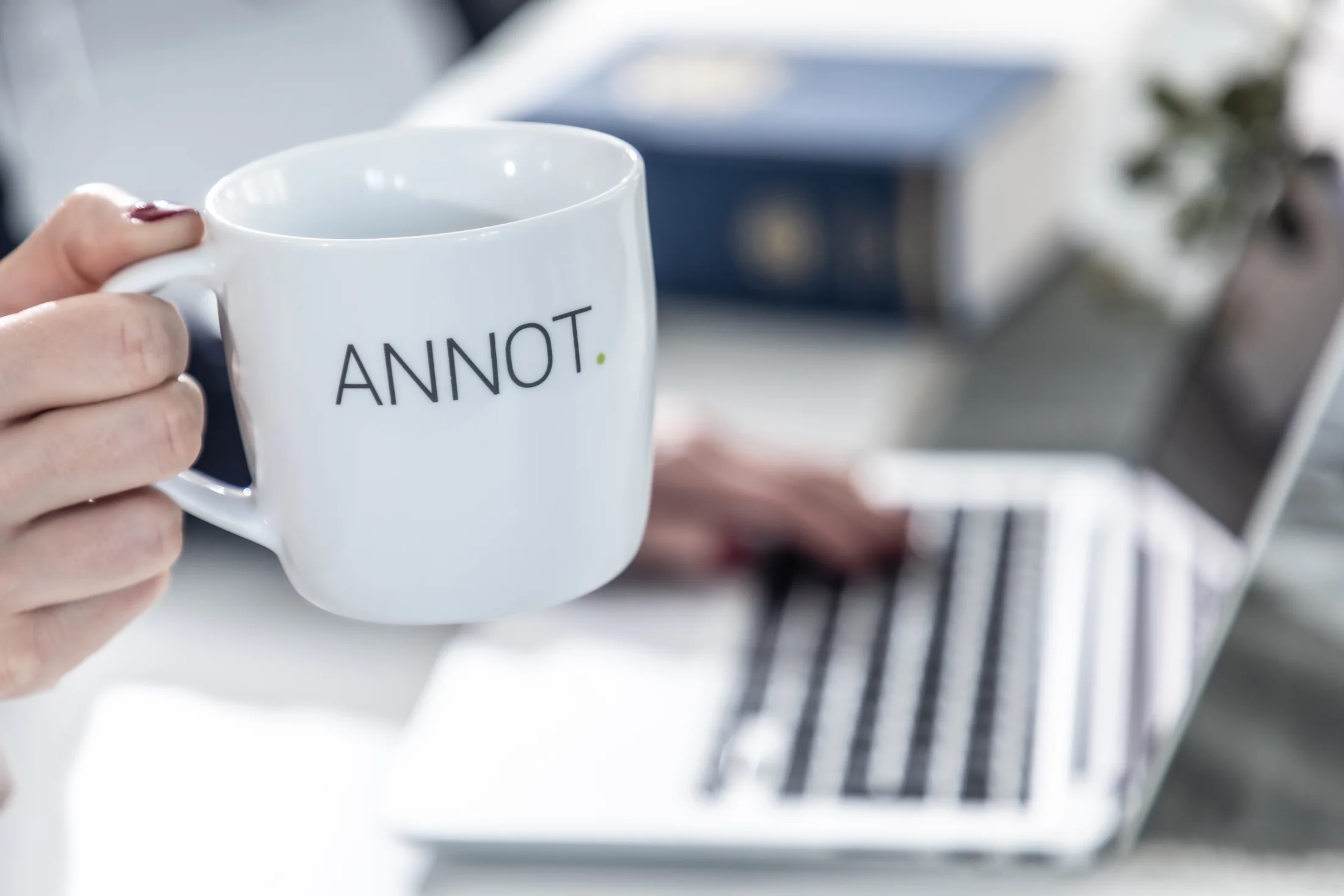 ANNOT-mugg och dator i kontorsmiljö